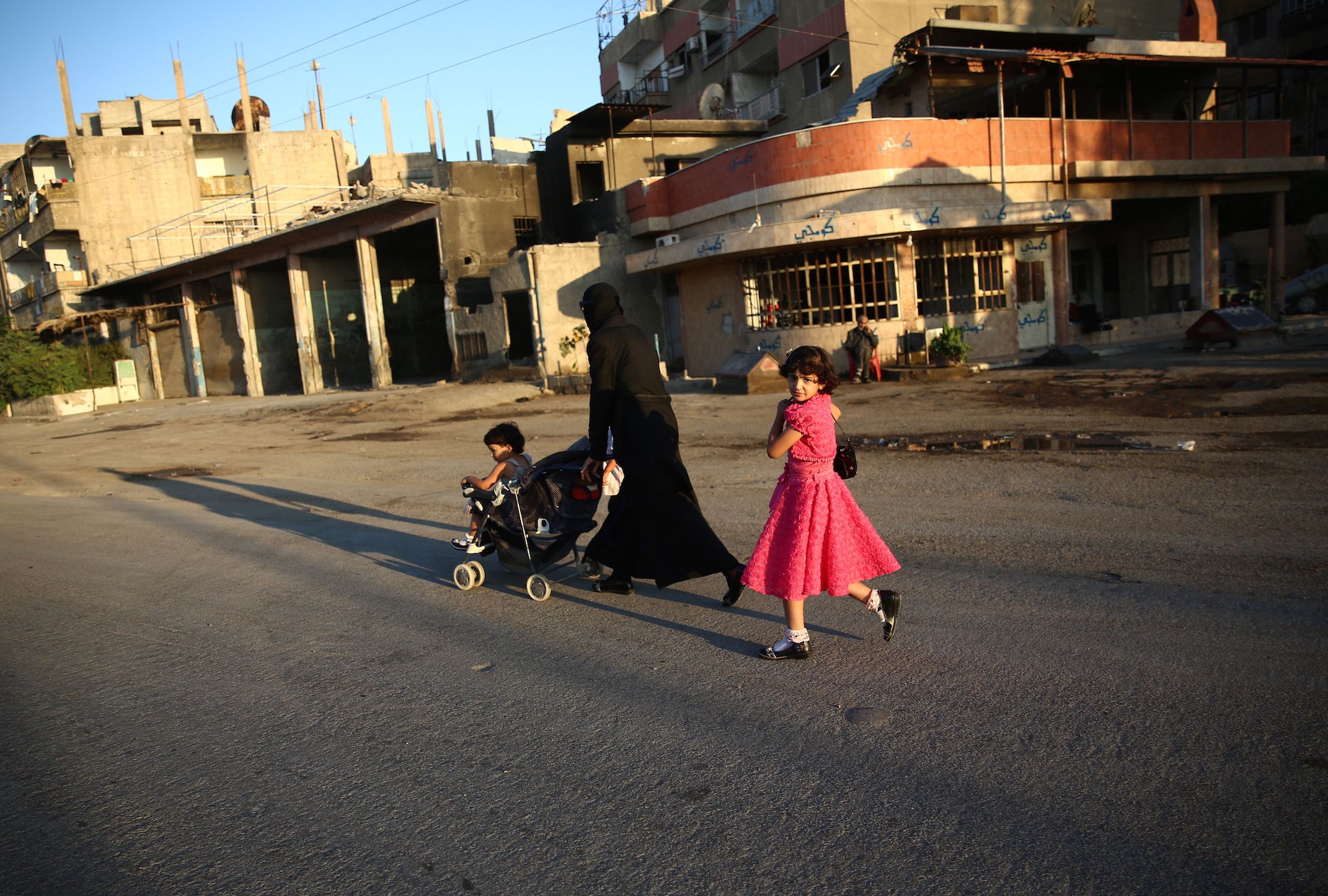 PHOTO: A Syrian girl walks with her mother in the rebel-held town of Douma east of the capital Damascus on the first day of the Eid al-Fitr holiday which marks the end of the Muslim holy fasting month of Ramadan on July 6, 2016.  