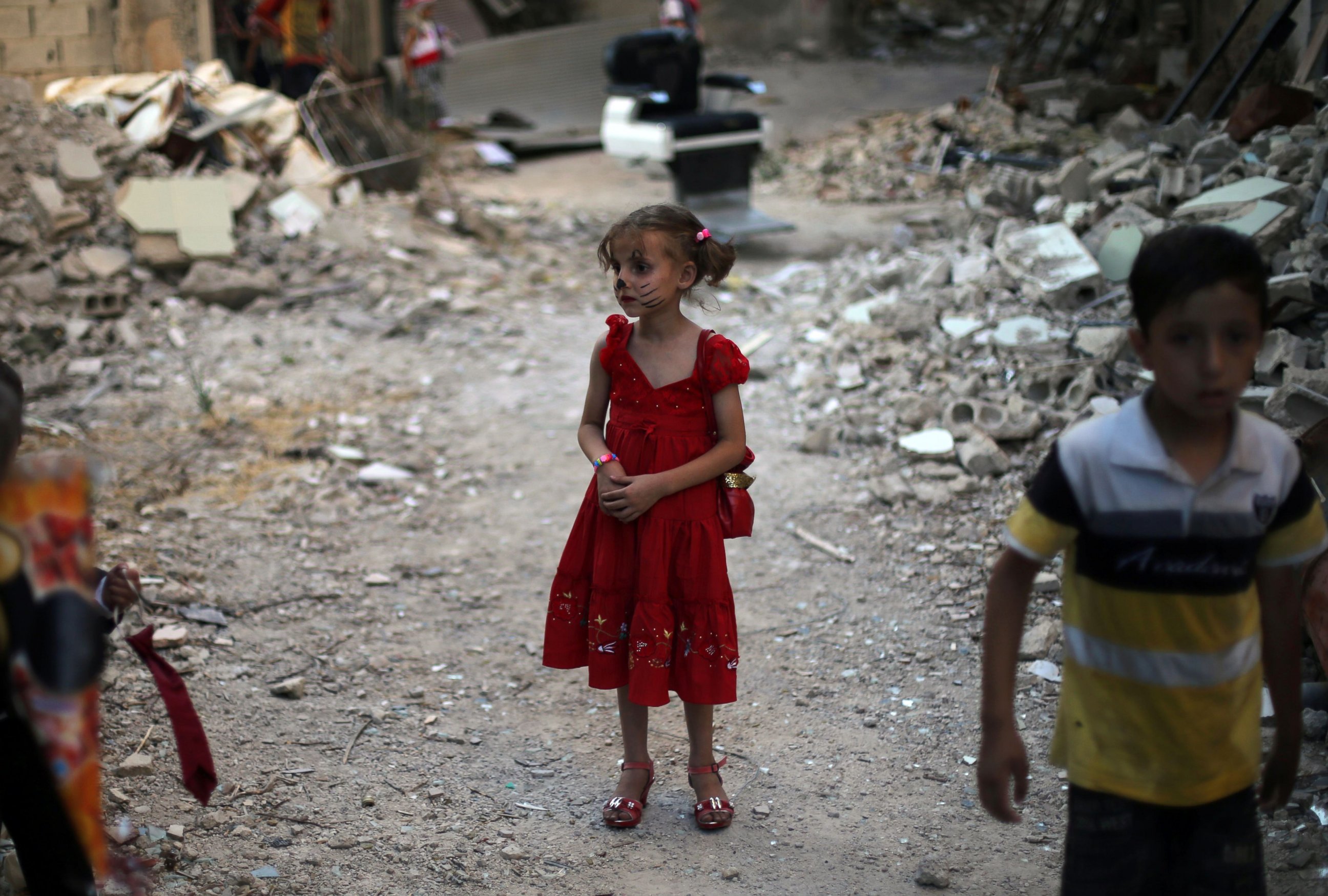 PHOTO: Syrian children stand amidst heavily damaged buildings on the eastern outskirts of the capital Damascus, ahead of Eid al-Fitr holiday in the war-torn country on July 5, 2016. 