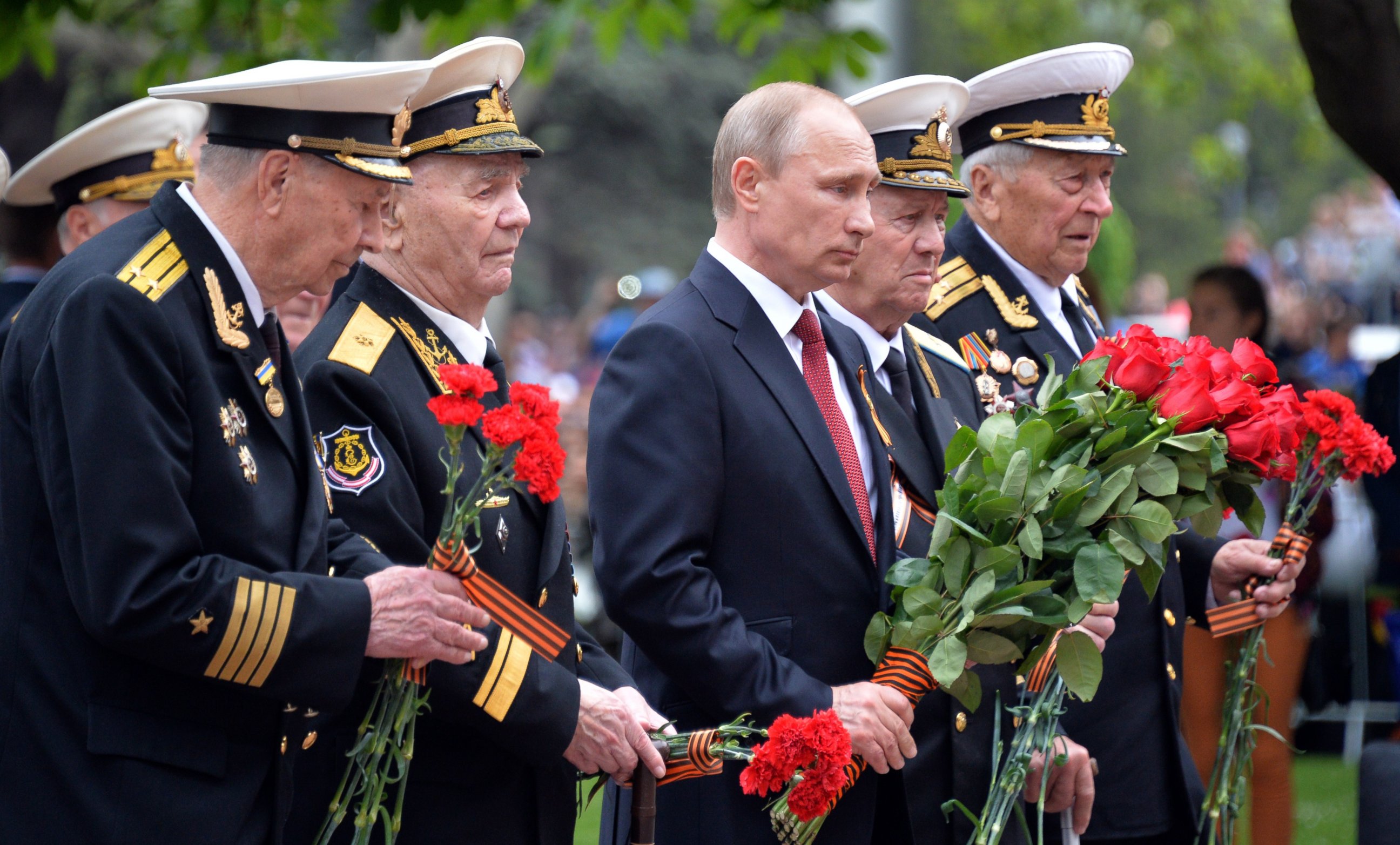 PHOTO: Russia's President Vladimir Putin, center, and World War II veterans law flowers at a war memorial during their visit to the Crimean port of Sevastopo, May 9, 2014. 