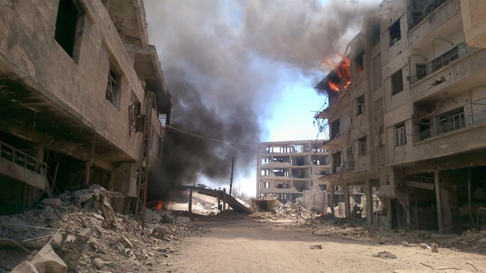 Fire and smoke gush out of buildings following reported air strikes on the Syrian besieged rebel-held town of Daraya near the capital Damascus, Aug. 16, 2016.  