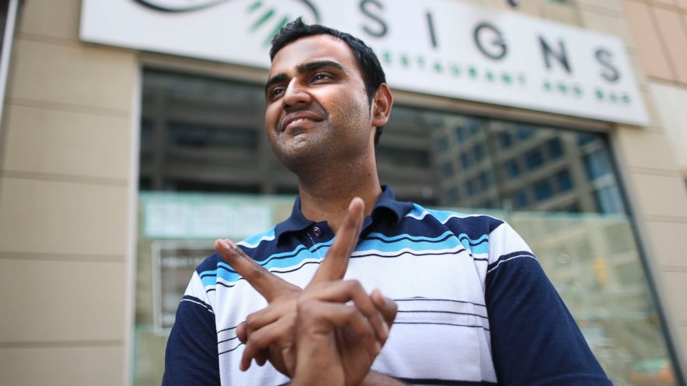 PHOTO: Owner Anjan Manikumar makes the sign for rabbit, one of the menu items at his restaurant Signs in Toronto on June 30, 2014.