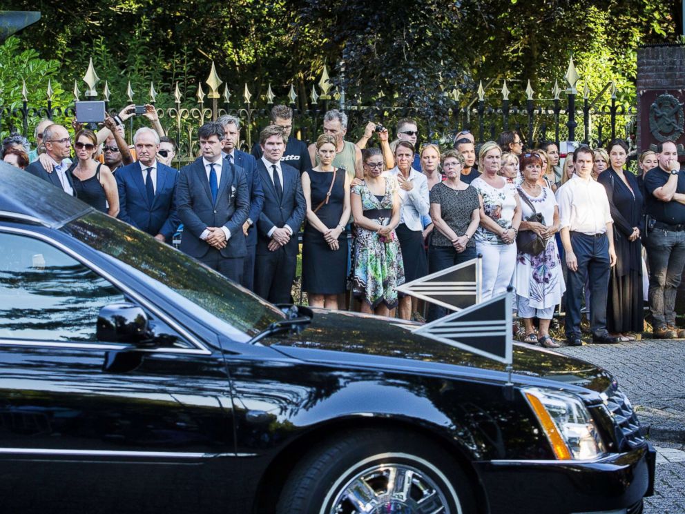 PHOTO: A convoy of hearses carrying coffins containing the remains of victims of the downed Malaysia Airlines flight MH17 passes in front a crowd of people lined up along the road on July 23, 2014 in Hilversum, the Netherlands.