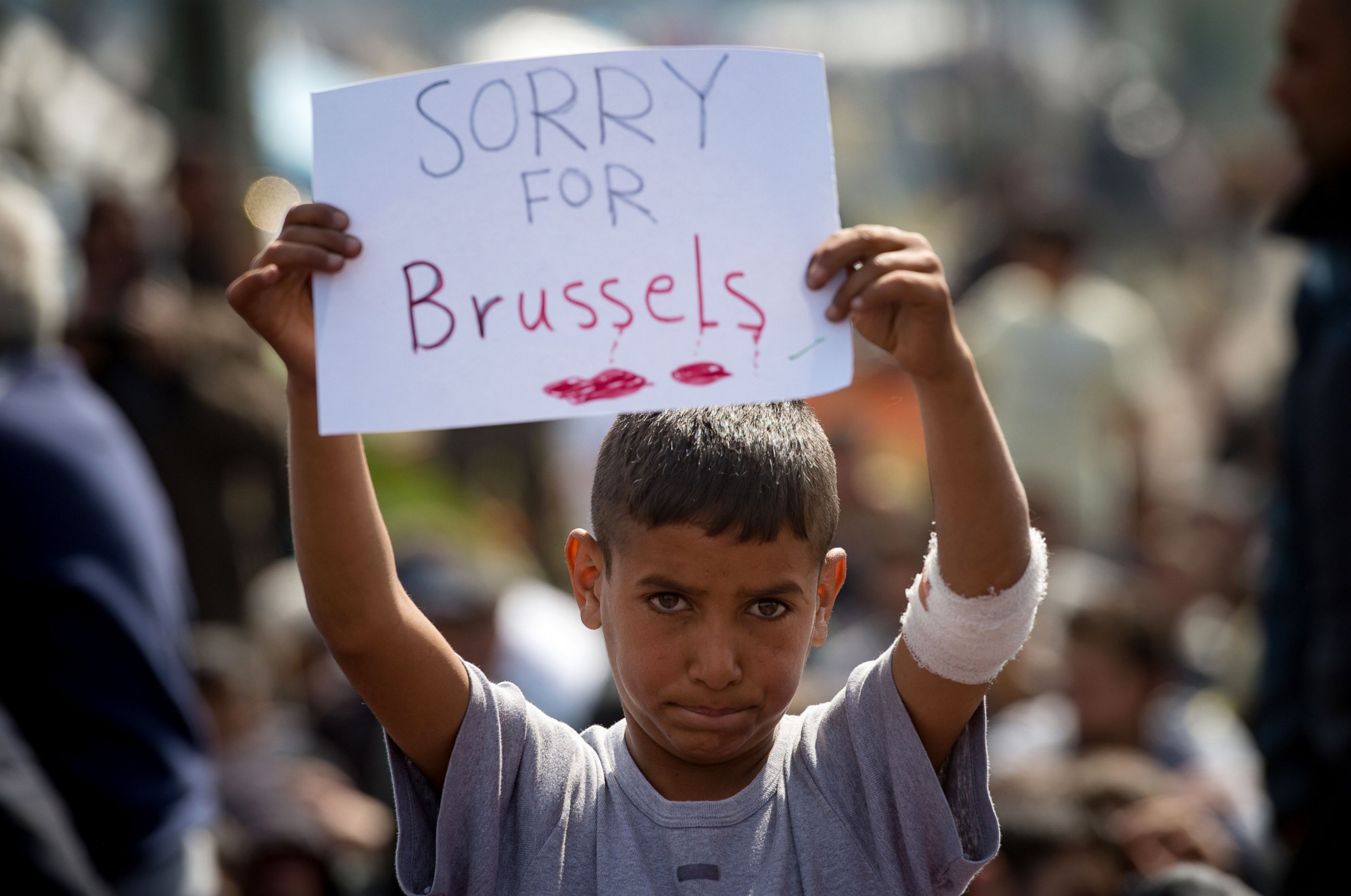 PHOTO: A boy holds a placard expressing sympathy for the victims of the terror attacks in Brussels during a protest at a makeshift camp at the Greek-Macedonian border near the village of Idomeni on March 22, 2016.