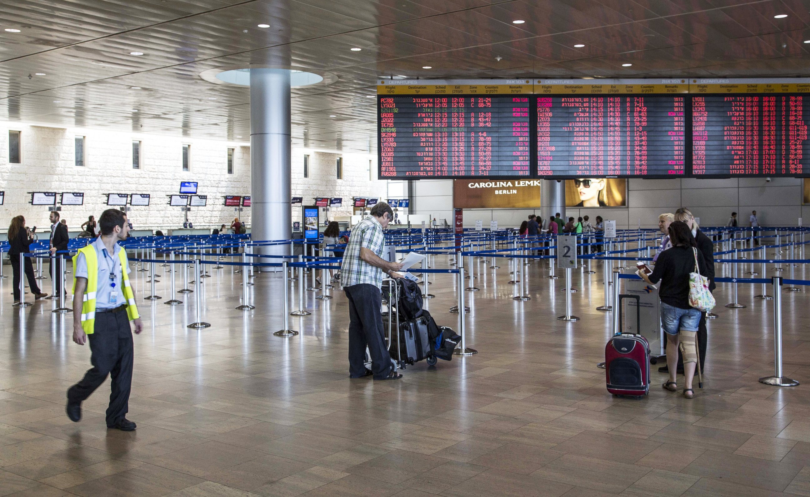 PHOTO: Israeli passengers walk near a departure time flight board displaying various cancellations at Ben Gurion International airport, near Tel Aviv, on July 23, 2014.