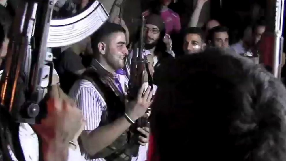 PHOTO: An image grab taken from AFP TV shows Syrian rebel sniper Abu Khaled (C) holding his gun as comrades celebrate during his wedding ceremony in Aleppo on August 31, 2012. 
