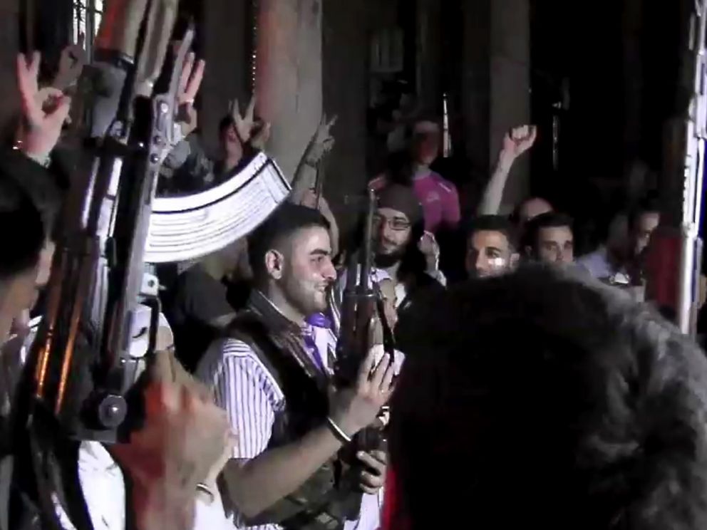 PHOTO: An image grab taken from AFP TV shows Syrian rebel sniper Abu Khaled (C) holding his gun as comrades celebrate during his wedding ceremony in Aleppo on August 31, 2012.