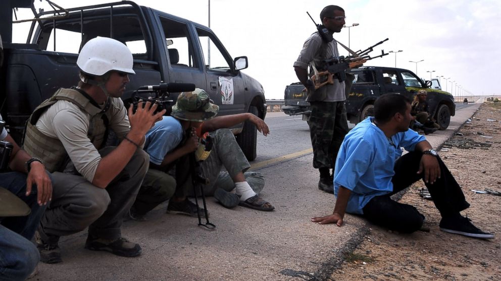 A photo taken on September 29, 2011 shows US freelance reporter James Foley (L) on the highway between the airport and the West Gate of Sirte, Libya. 