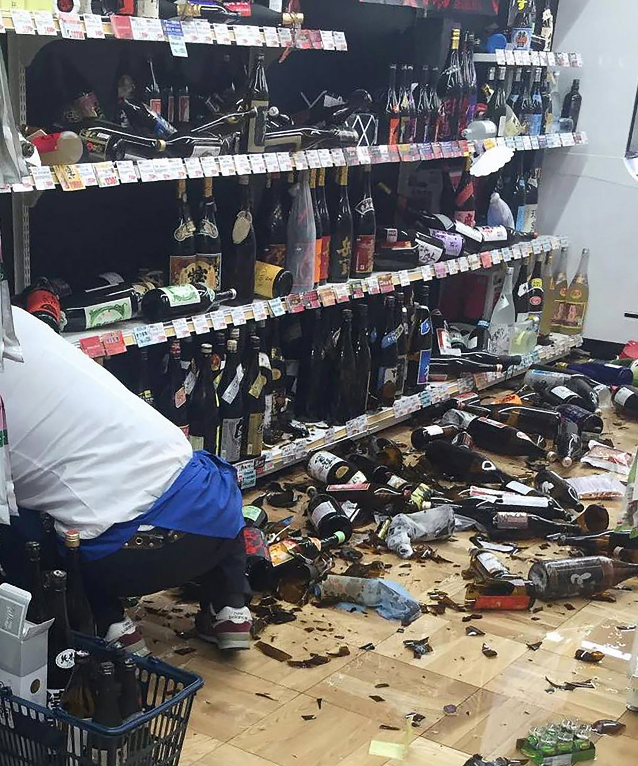 PHOTO: A shop clerk cleans broken wine bottles following an earthquake in Kumamoto, Japan on April 14, 2016.