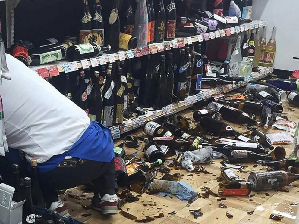 PHOTO: A shop clerk cleans broken wine bottles following an earthquake in Kumamoto, Japan on April 14, 2016.