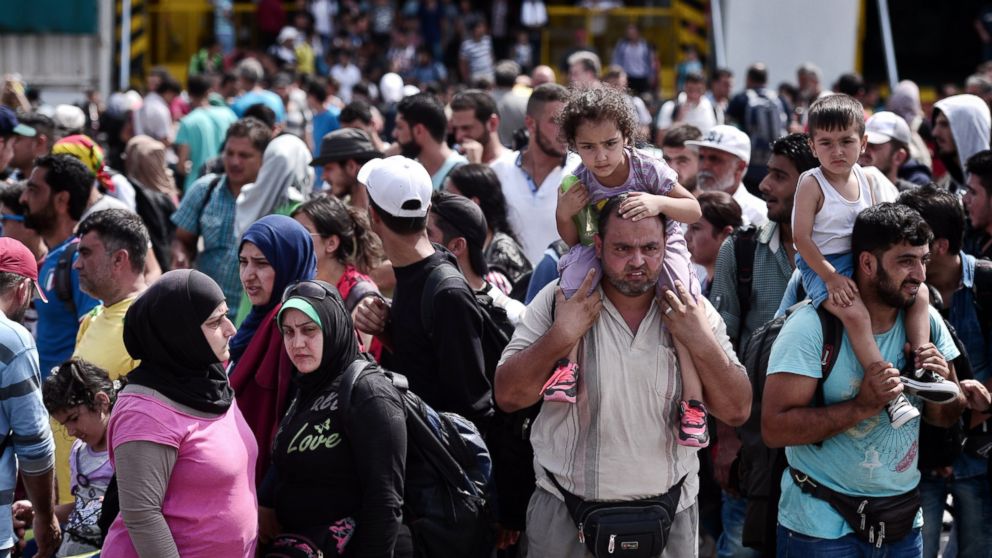 Refugees and migrants disembark from a Greek government chartered ferry in the port of Piraeus on Sept. 9, 2015.