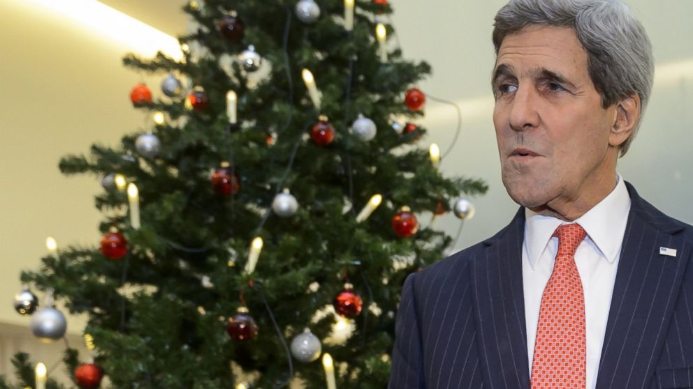 Secretary of State John Kerry gestures as he stands next to a Christmas tree on the eve of an Organization for Security and Cooperation in Europe ministerial meeting in Basel, Switzerland, Dec. 3, 2014.