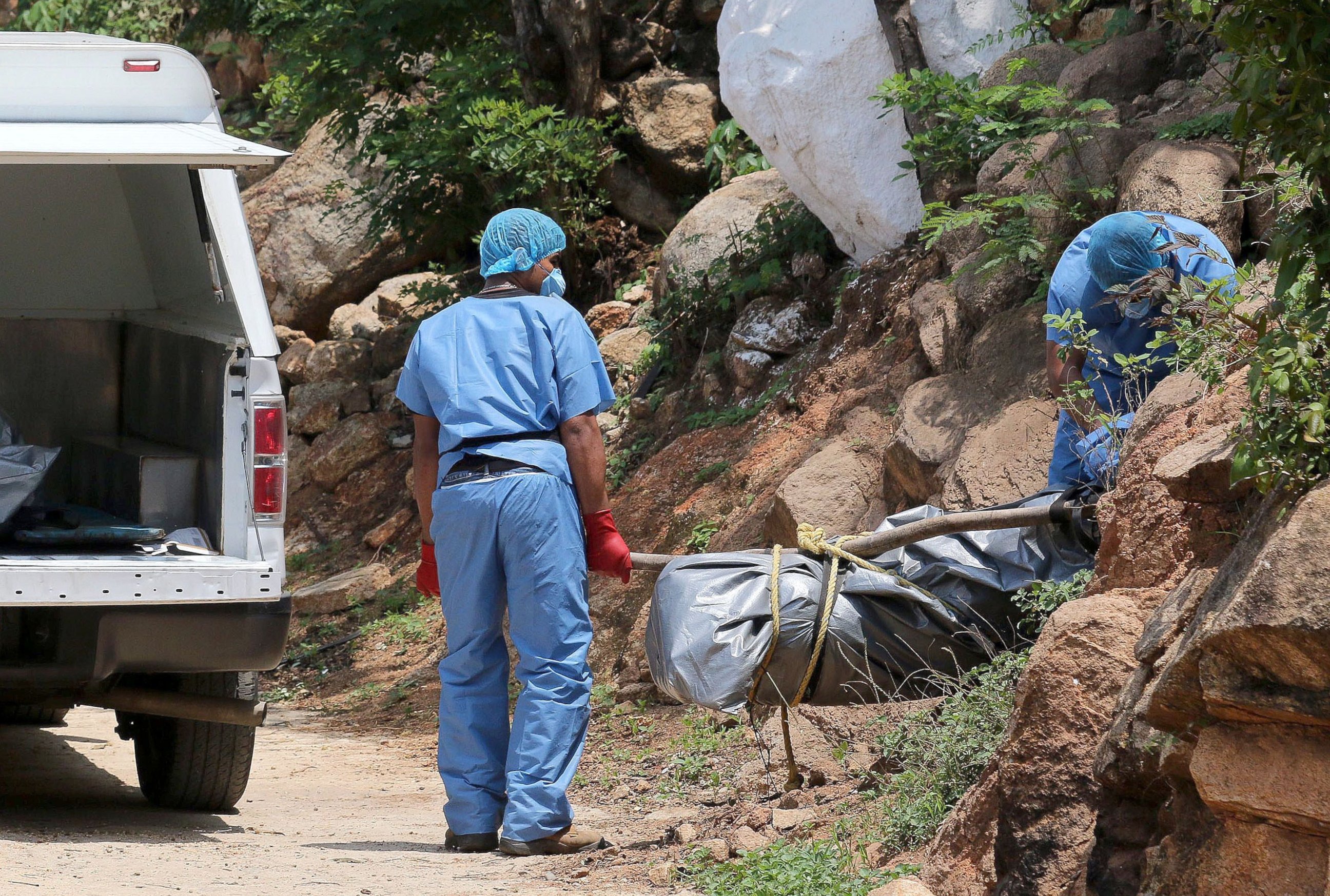 PHOTO: Forensic personnel load onto a van the body of one of the ten bodies found in clandestine graves in the tourist city of Acapulco, Guerrero State on June 22, 2015. 