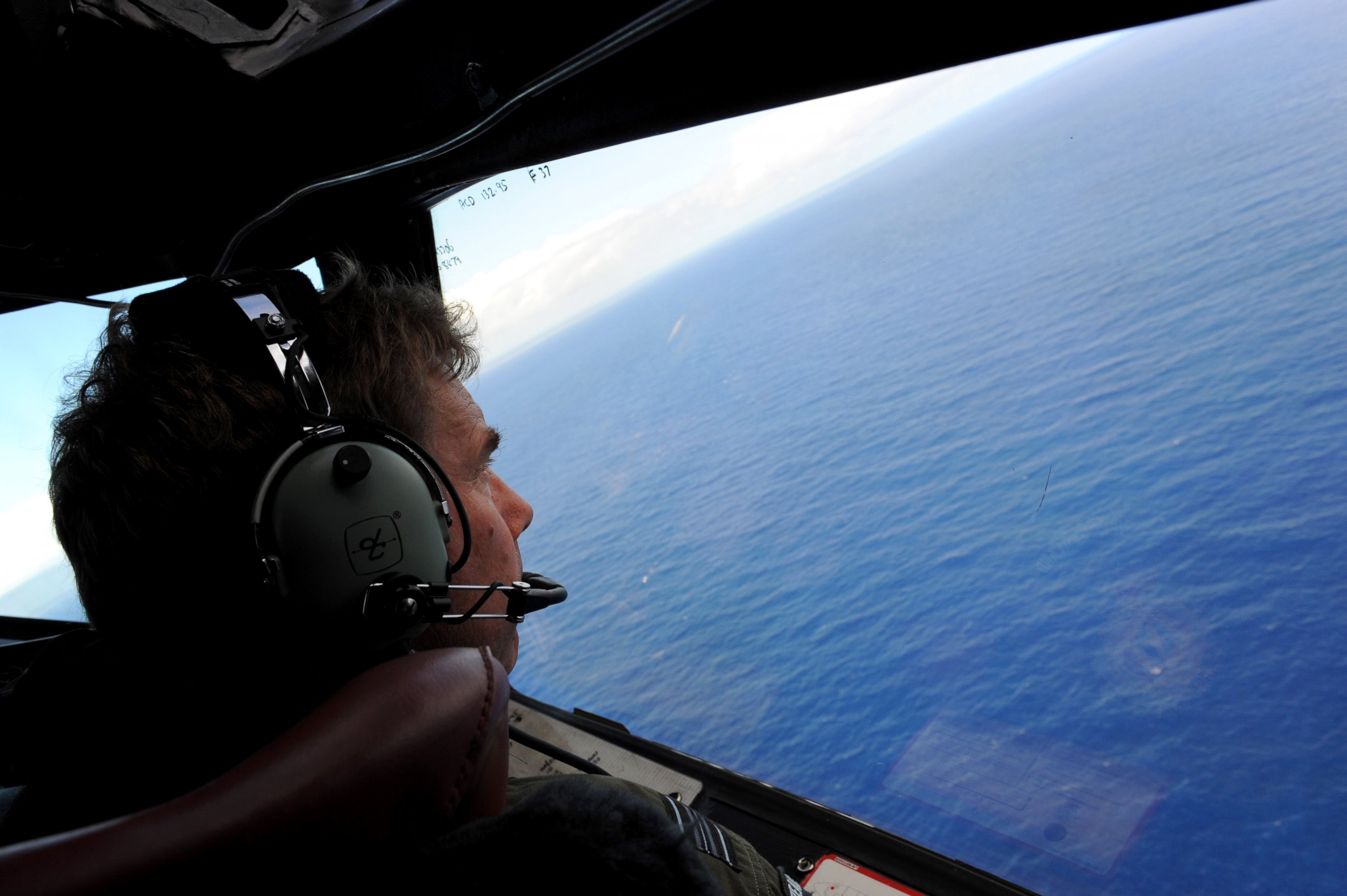 PHOTO: Co-pilot and Squadron Leader Brett McKenzie of the Royal New Zealand Airforce P-3K2-Orion aircraft, helps to look for objects during the search for missing flight MH370 in flight over the Indian Ocean off the coast of Perth, Australia. 