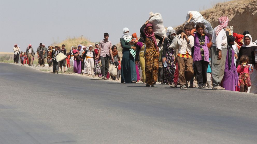 PHOTO: Displaced Iraqi families from the Yazidi community cross the Iraqi-Syrian border at the Fishkhabur crossing, in northern Iraq, on August 13, 2014.