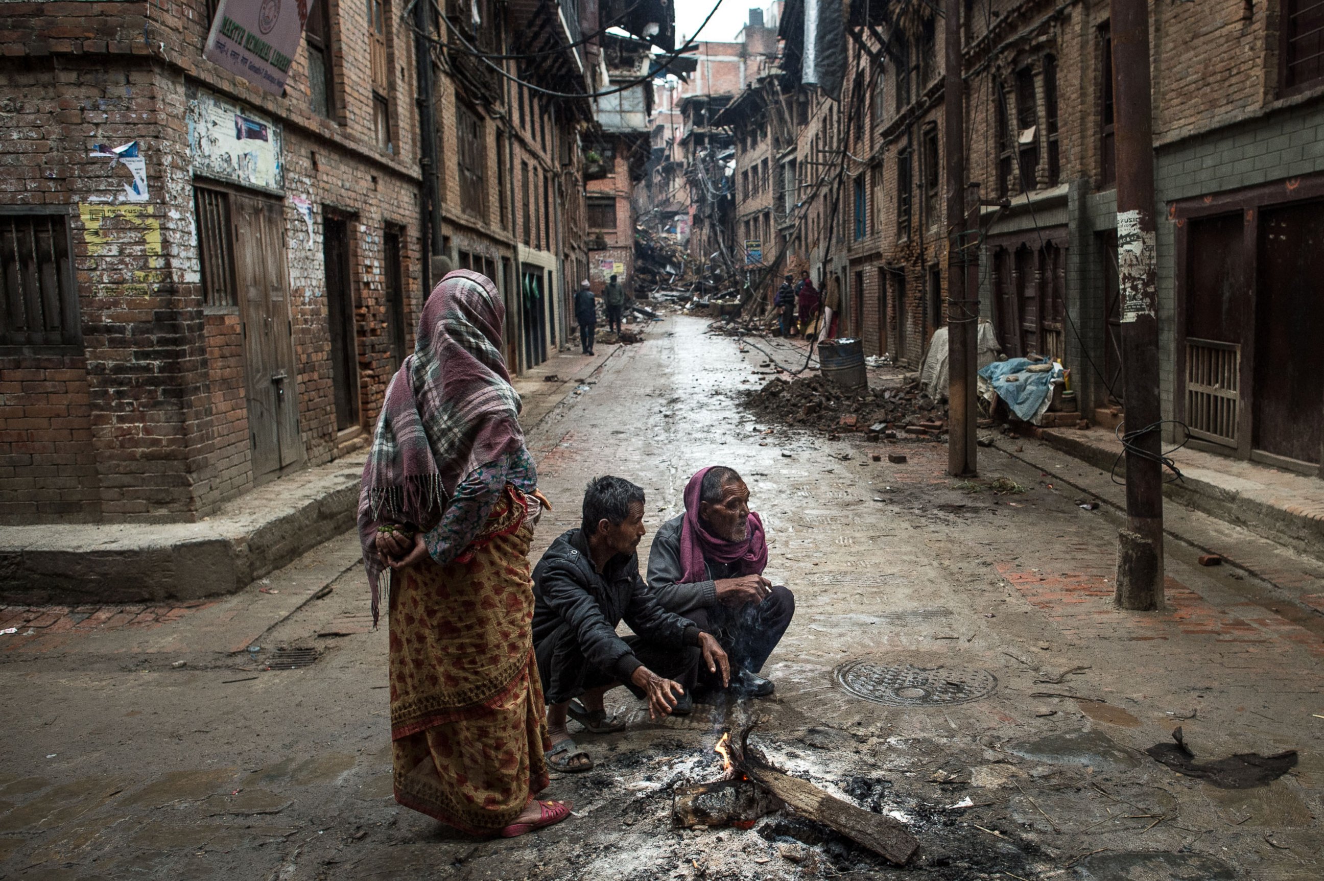 PHOTO: Local residents warm themselves by a fire in the street in Bhaktapur on April 30, 2015 in Kathmandu, Nepal.