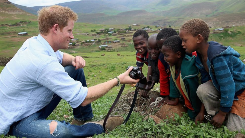 PHOTO: Prince Harry shows children a photograph he has taken on a digital camera during a visit to a herd boy night school constructed by Sentebale on Dec. 8, 2014 in Mokhotlong, Lesotho.
