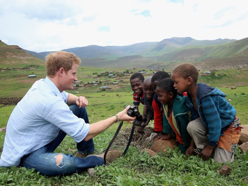 PHOTO: Prince Harry shows children a photograph he has taken on a digital camera during a visit to a herd boy night school constructed by Sentebale on Dec. 8, 2014 in Mokhotlong, Lesotho.