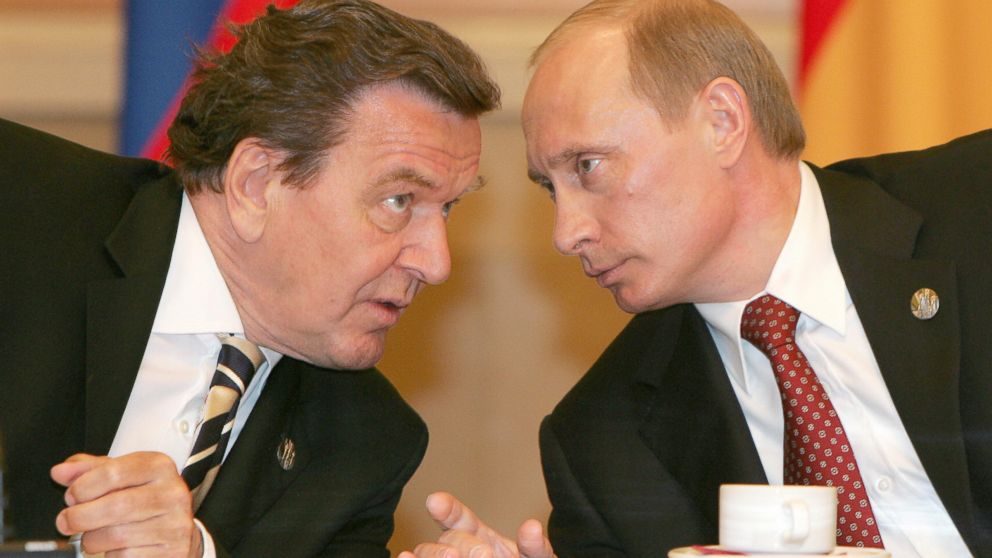 Russian President Vladimir Putin (R) talks to and German Chancellor Gerhard Schroeder during their meeting in Moscow, May 9, 2005. 