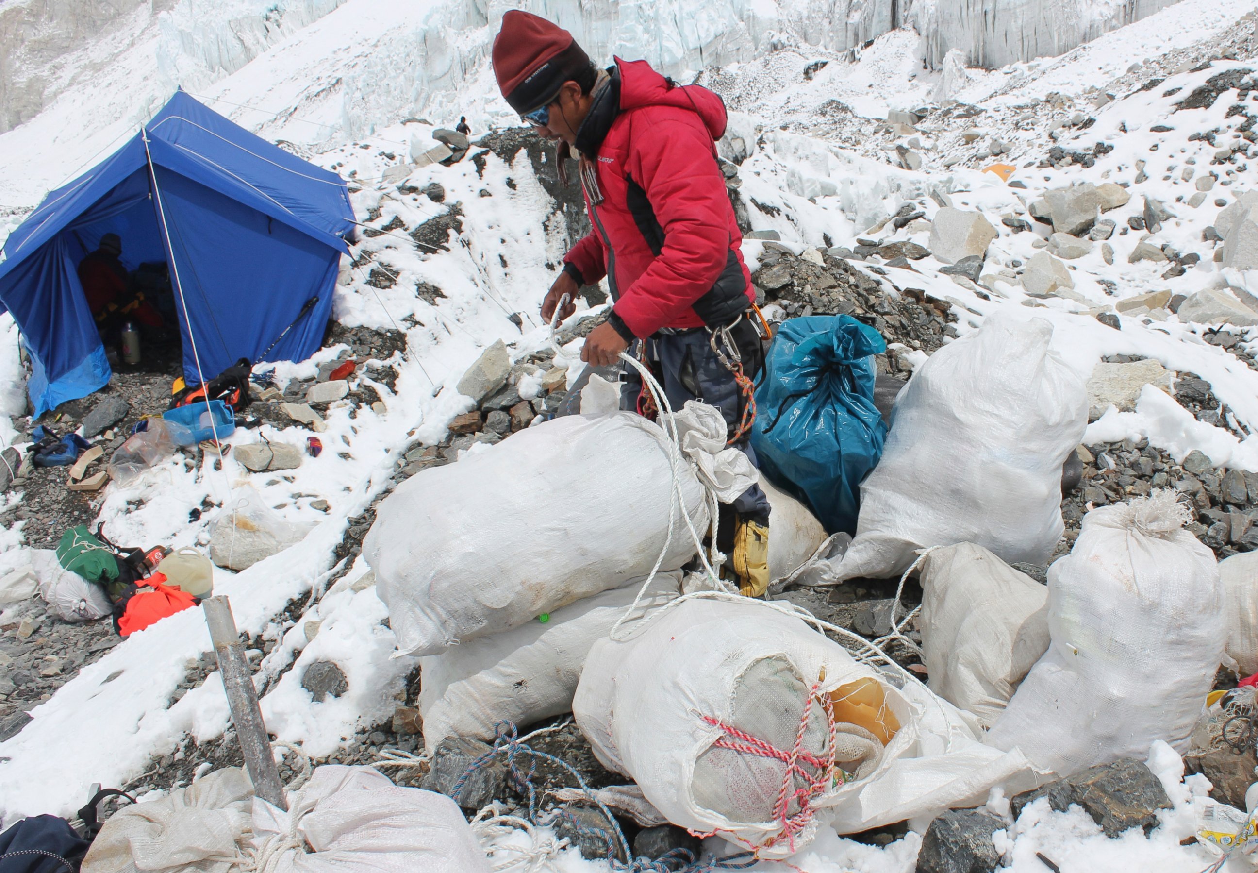 PHOTO: This picture taken on May 26, 2010 shows a Nepalese sherpa packing garbage collected from the Everest clean-up expedition at Everest Base Camp. 