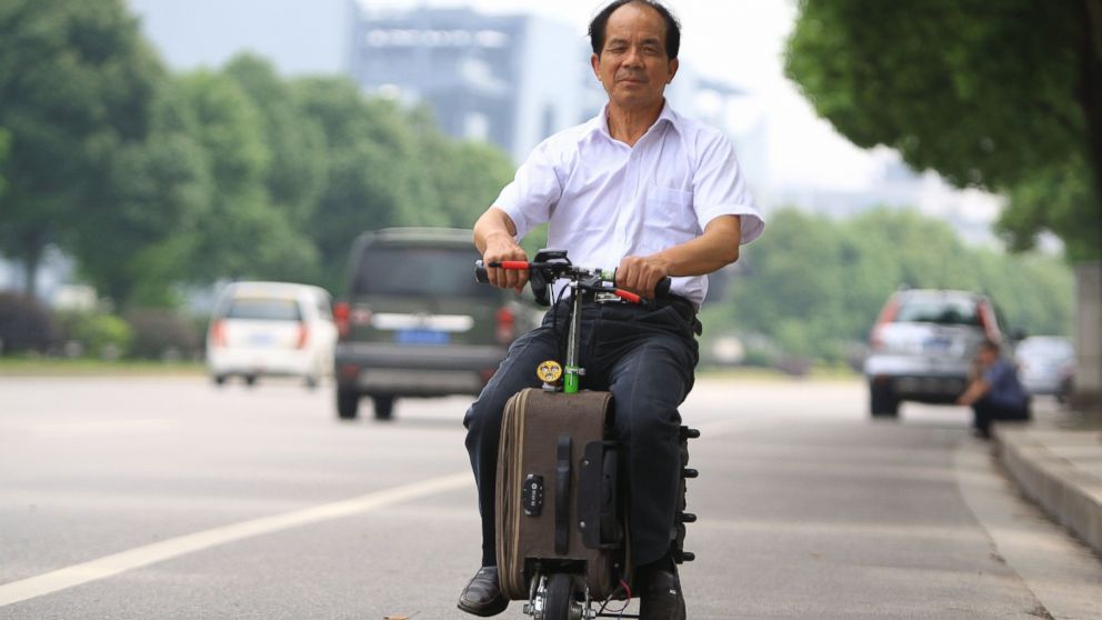 PHOTO: Chinese farmer He Liangcai spent ten years developing his motorized scooter suitcase and rides it regularly around Changsha, central China's Hunan province.
