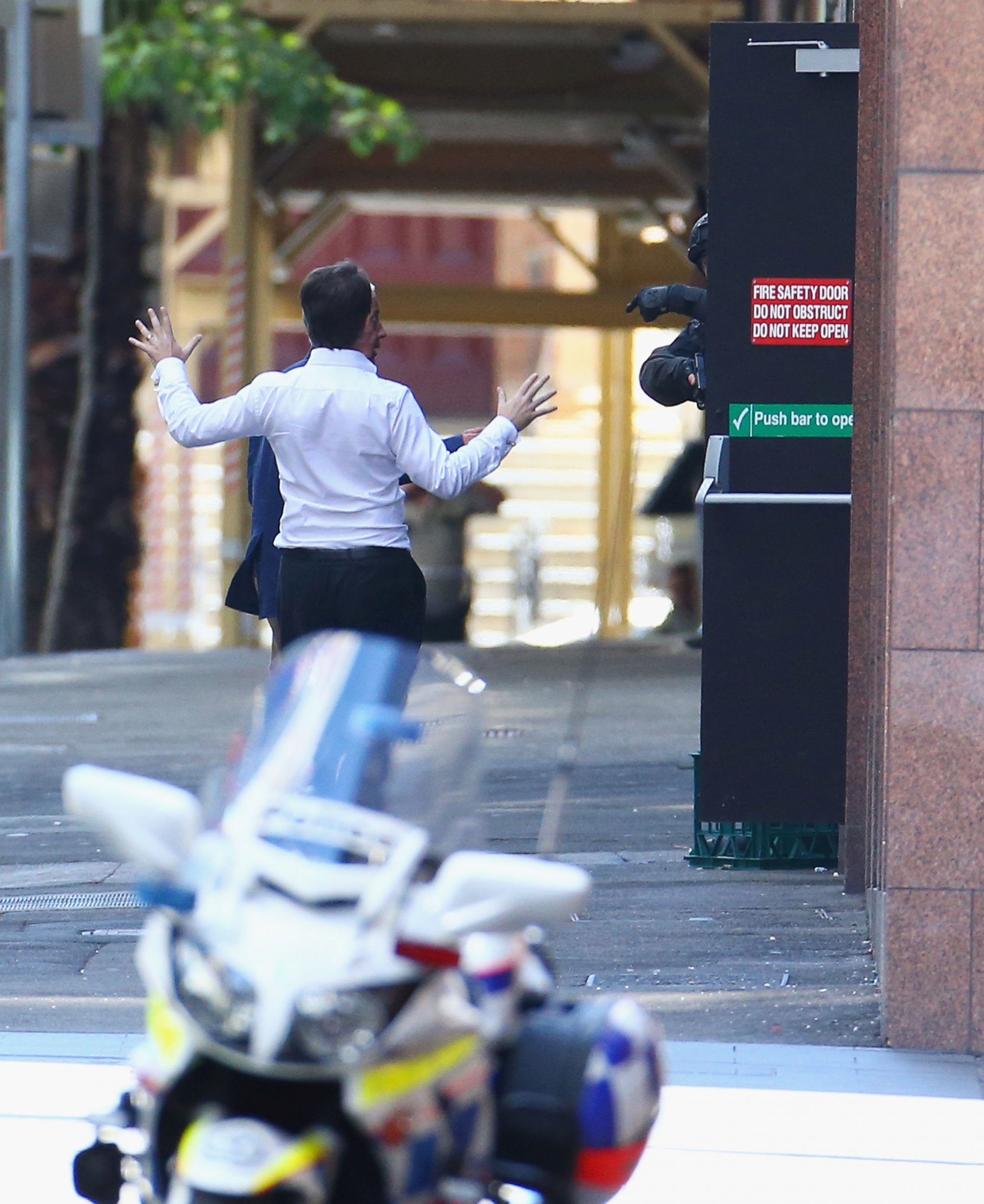 PHOTO: Two hostages run to safety outside the Lindt Cafe, Martin Place on December 15, 2014 in Sydney, Australia. 