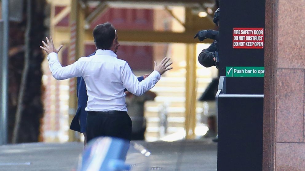 PHOTO: Two hostages run to safety outside the Lindt Cafe, Martin Place on December 15, 2014 in Sydney, Australia. 