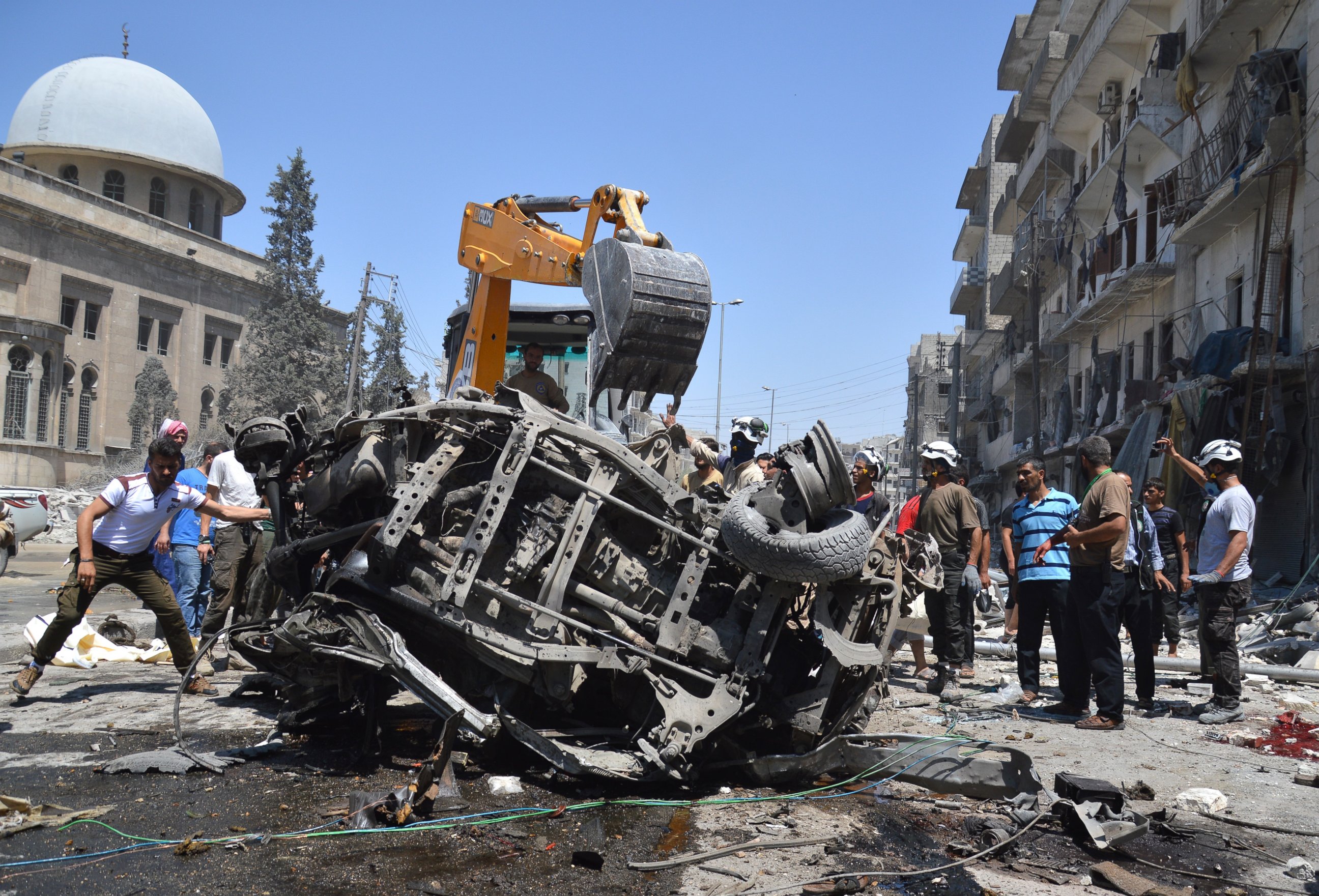 PHOTO: A damaged car is removed after Syrian and Russian warplanes targeted the Salhiyn neighborhood in Aleppo, Syria on July 21, 2016.