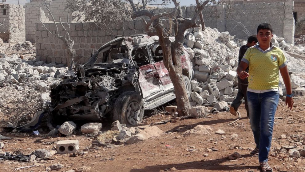 PHOTO: A Syrian youth walks past the wreckage of a vehicle following the U.S.-led coalition airstrikes against ISIS in a residential area in Idlib, Syria on Sept. 23, 2014.