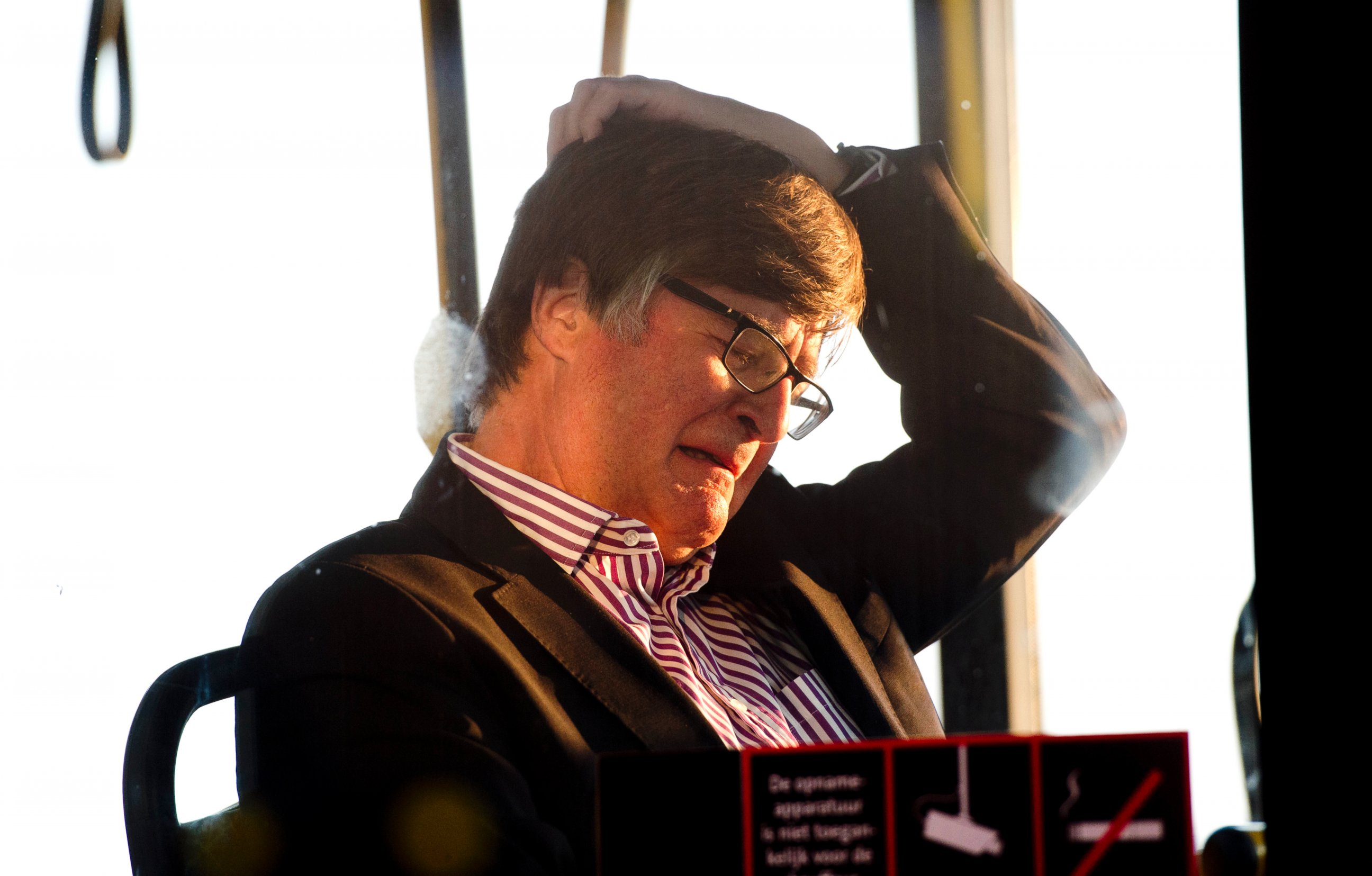 PHOTO: The family member of a passenger killed in the crash of Air Malaysia flight MH17 grieves as he waits on a bus to depart Schiphol airport in Amsterdam, Netherlands. 