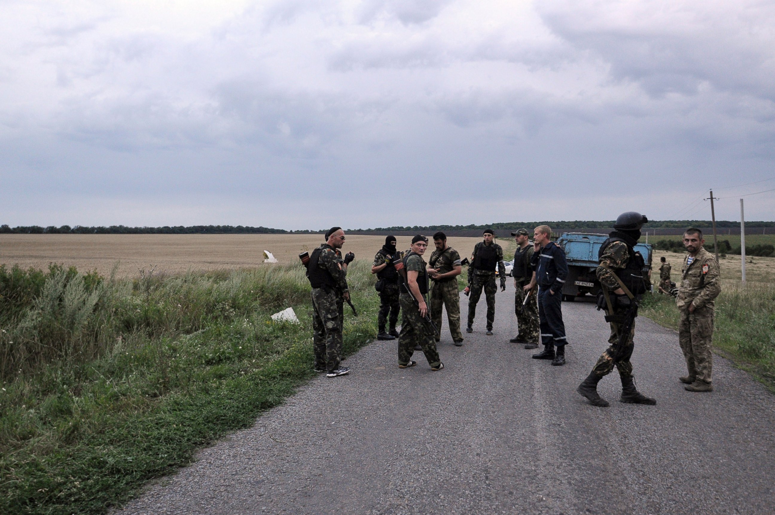 PHOTO: Men wearing military fatigues stand on a road at the site of the wreckage of a Malaysian airliner in rebel-held east Ukraine on July 17, 2014.