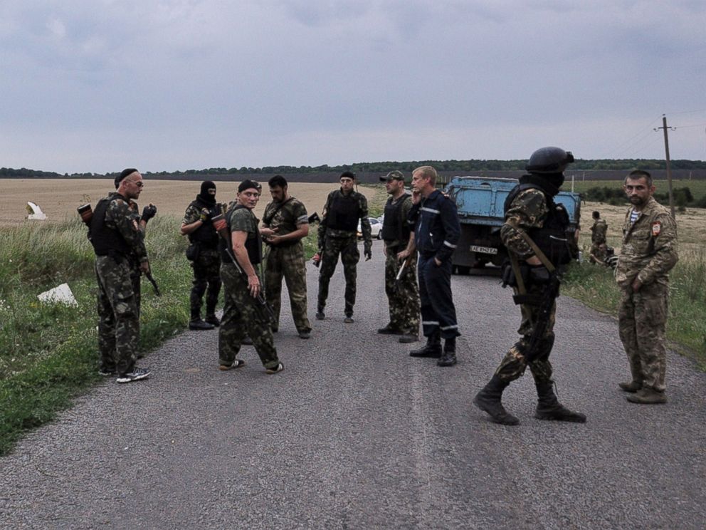 PHOTO: Men wearing military fatigues stand on a road at the site of the wreckage of a Malaysian airliner in rebel-held east Ukraine on July 17, 2014.