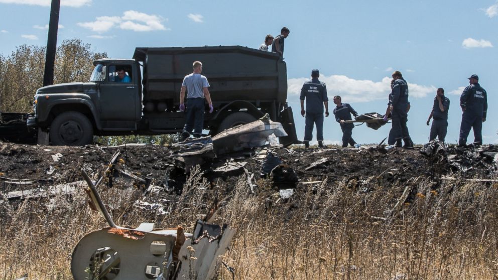 Personnel from the Ukrainian Emergencies Ministry load the bodies of victims of Malaysia Airlines flight MH17 into a truck at the crash site on July 21, 2014 in Grabovo, Ukraine.