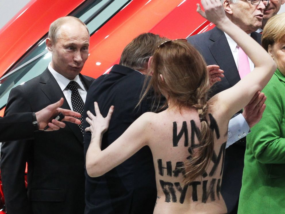 PHOTO: Russian President Vladimir Putin is attacked by an activist of the Ukrainian women rights group "Femen" during a visit with German Chancellor Angela Merkel on April 8, 2013 in Hannover, Germany.