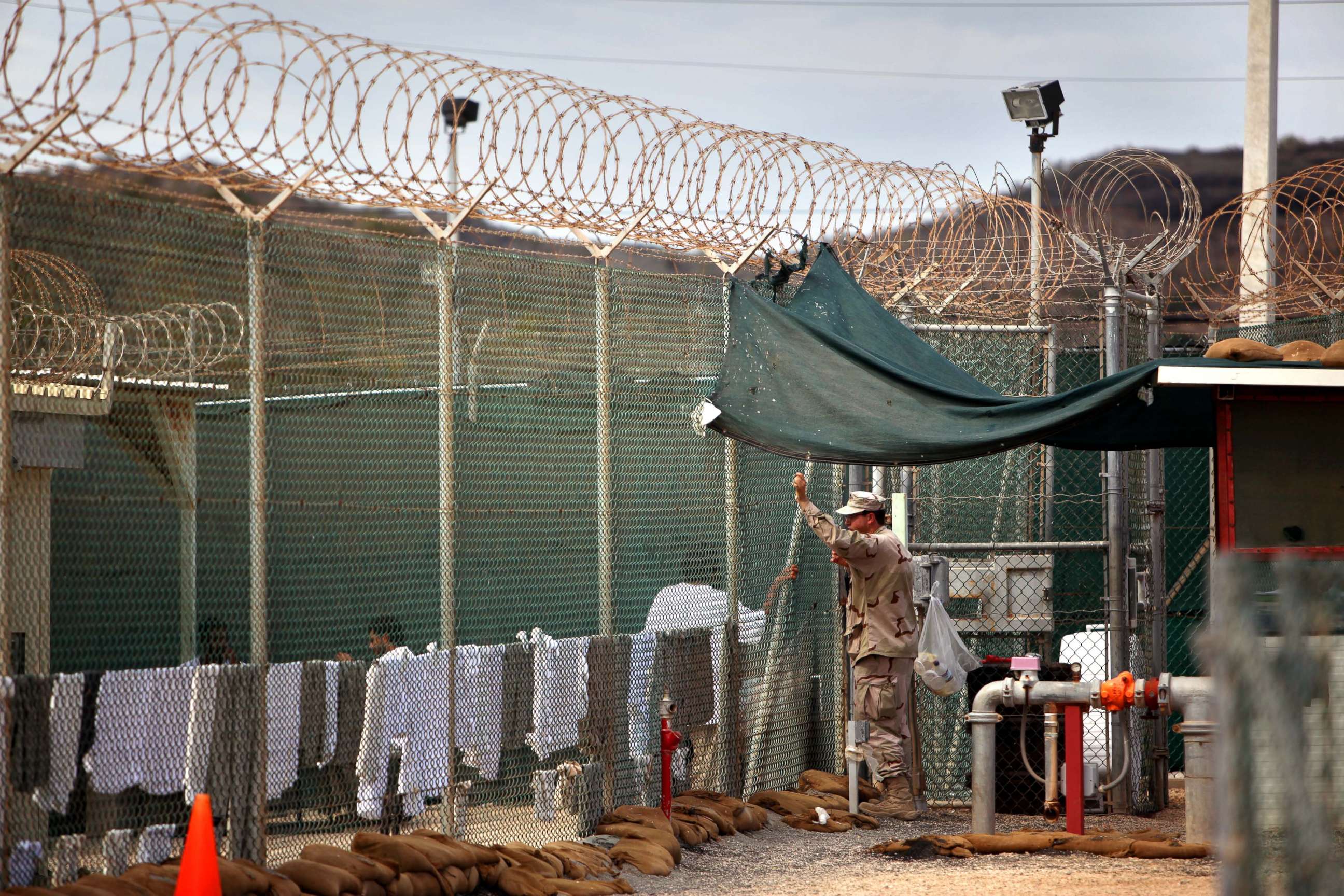 PHOTO: A U.S. Army guard leans on a fence talking to a Guantanamo detainee, inside the open yard at Camp 4 detention center, at the U.S. Naval Base, in Guantanamo Bay, Cuba, Jan. 21, 2009.