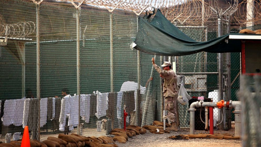 PHOTO: A U.S. Army guard leans on a fence talking to a Guantanamo detainee, inside the open yard at Camp 4 detention center, at the U.S. Naval Base, in Guantanamo Bay, Cuba, Jan. 21, 2009.