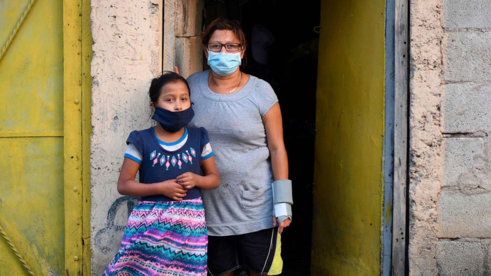 PHOTO: Locals wear face masks as a preventive measure against the spread of new coronavirus, COVID-19, during a partial curfew ordered by the government, at Las Brisas del Lago neighborhood, in Villa Nueva. south Guatemala City on April 14, 2020.