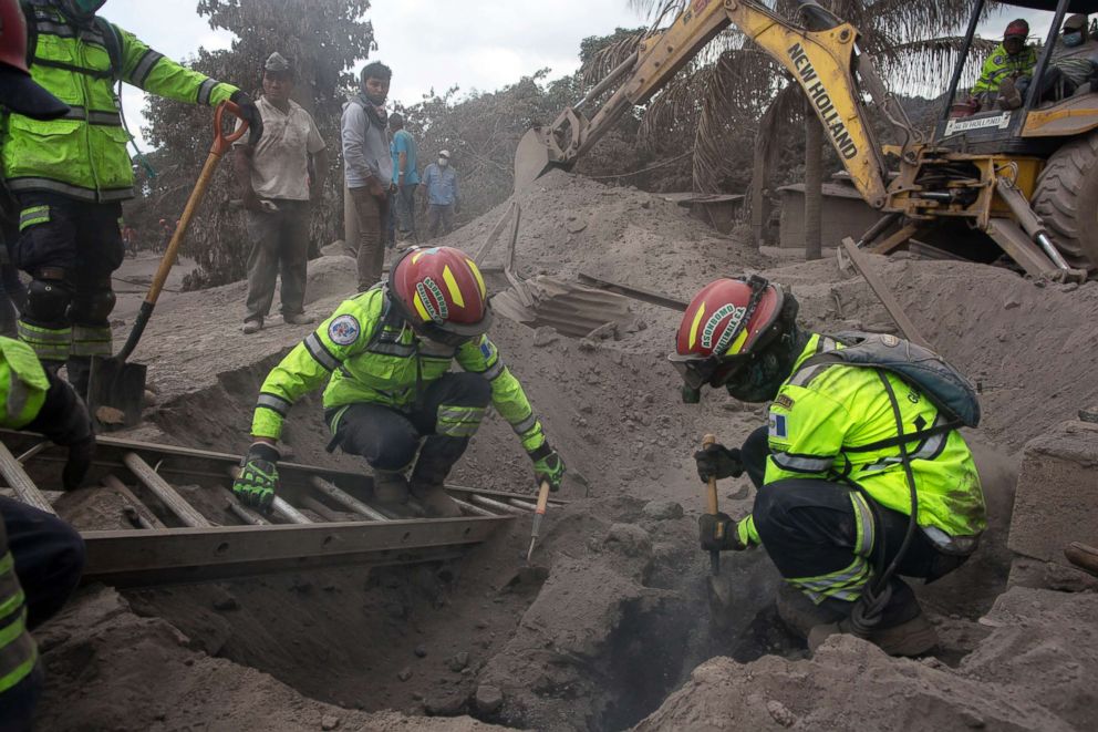 PHOTO: Firefighters remove a burned body buried in volcanic ash in the disaster zone near the Volcan de Fuego, or Volcano of Fire, in the El Rodeo hamlet of Escuintla, Guatemala, June 5, 2018.