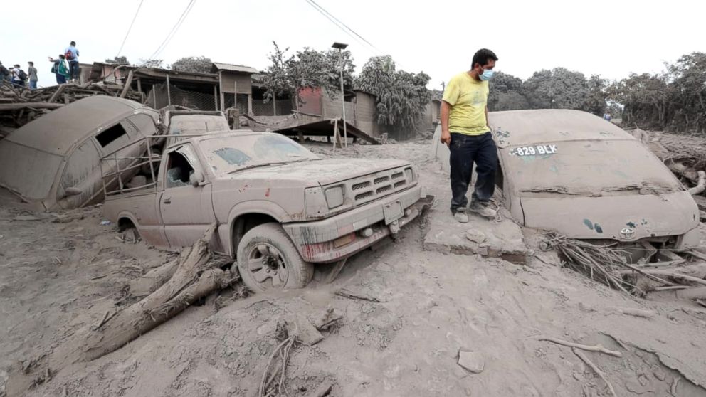 PHOTO: A man stands by damaged vehicles covered by ash in San Miguel Los Lotes, a village in Escuintla, Guatemala, June 4, 2018.