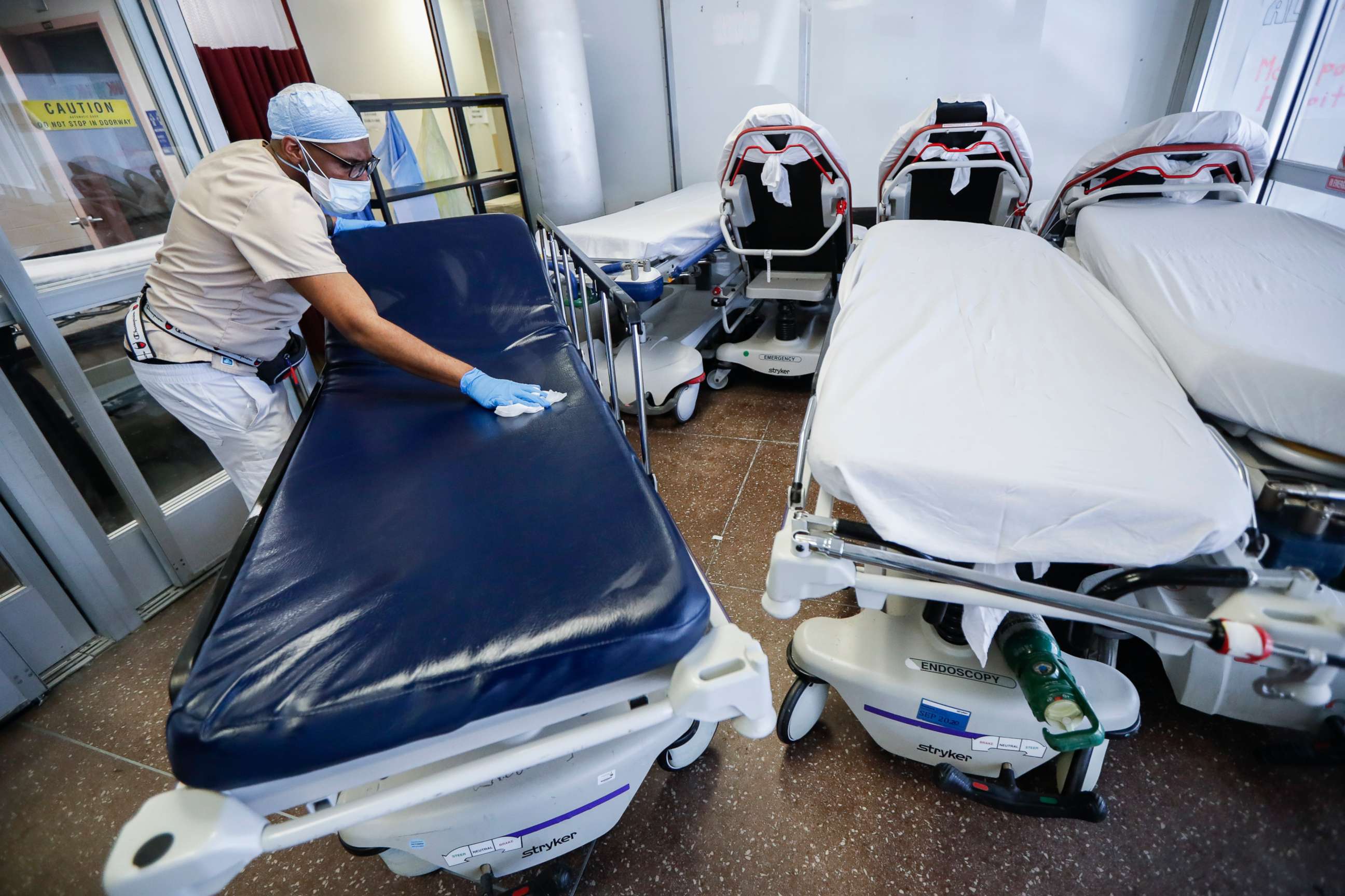 PHOTO: A medical worker wearing personal protective equipment cleans gurneys in the emergency department intake area at NYC Health + Hospitals Metropolitan, in New York.