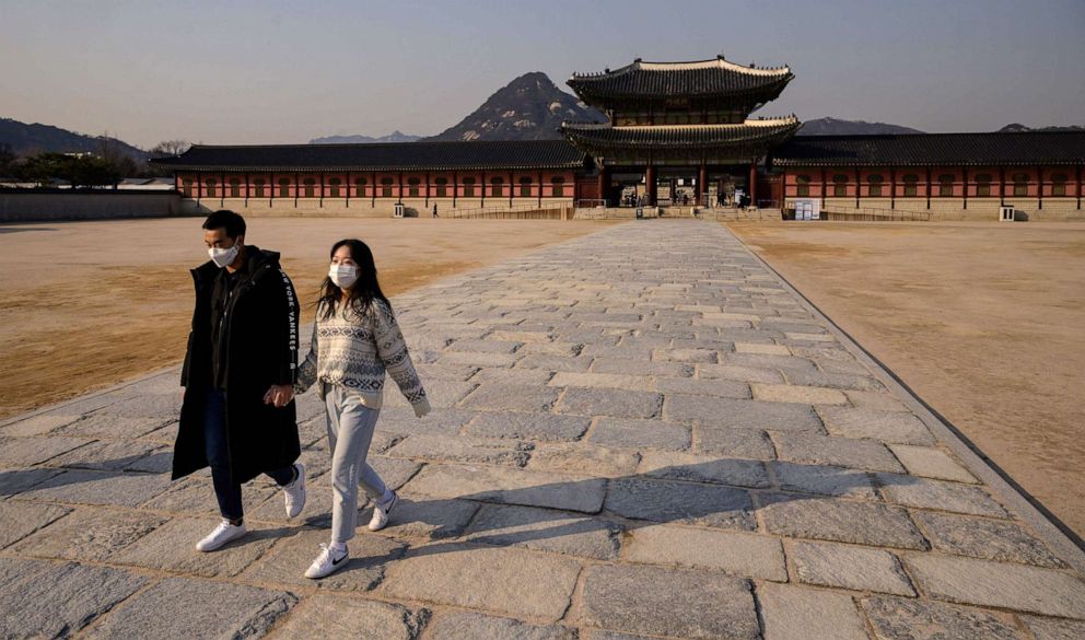 PHOTO: Visitors wearing face masks, amid concerns about the spread of the COVID-19 novel coronavirus, walk through a courtyard of Gyeongbokgung palace in central Seoul on March 6, 2020.