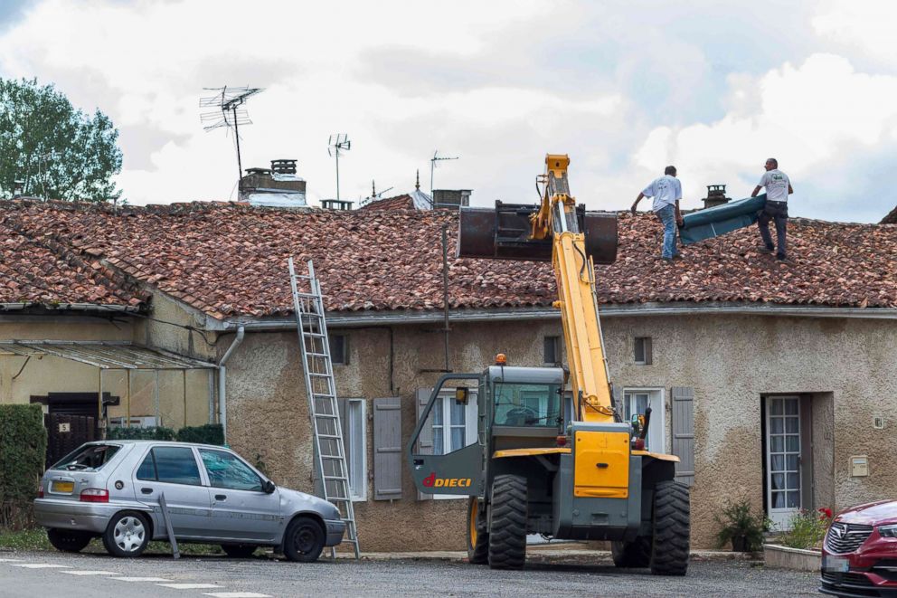 PHOTO: Workers repair the roof of a building in the village of Saint-Sornin, July 5, 2018, after violent hailstorms ripped through the area 50 miles north-west of Bordeaux in western France late July 4.