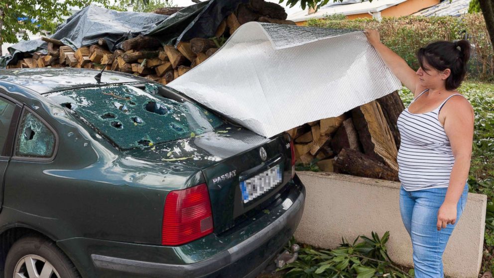 PHOTO: A woman shows the rear window of a damaged vehicle in the village of Saint-Sornin, July 5, 2018, after violent hailstorms ripped through the area some 50 miles north-west of Bordeaux in western France late July 4.
