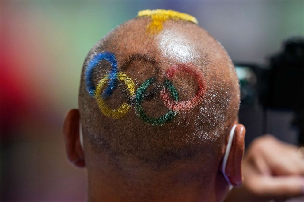 PHOTO: Mongolian coach Undralbat Lkhagva has the Olympic rings cut and dyed into his hair as he watches the women's 10-meter air pistol at the Asaka Shooting Range in the 2020 Summer Olympics, July 25, 2021, in Tokyo, Japan.