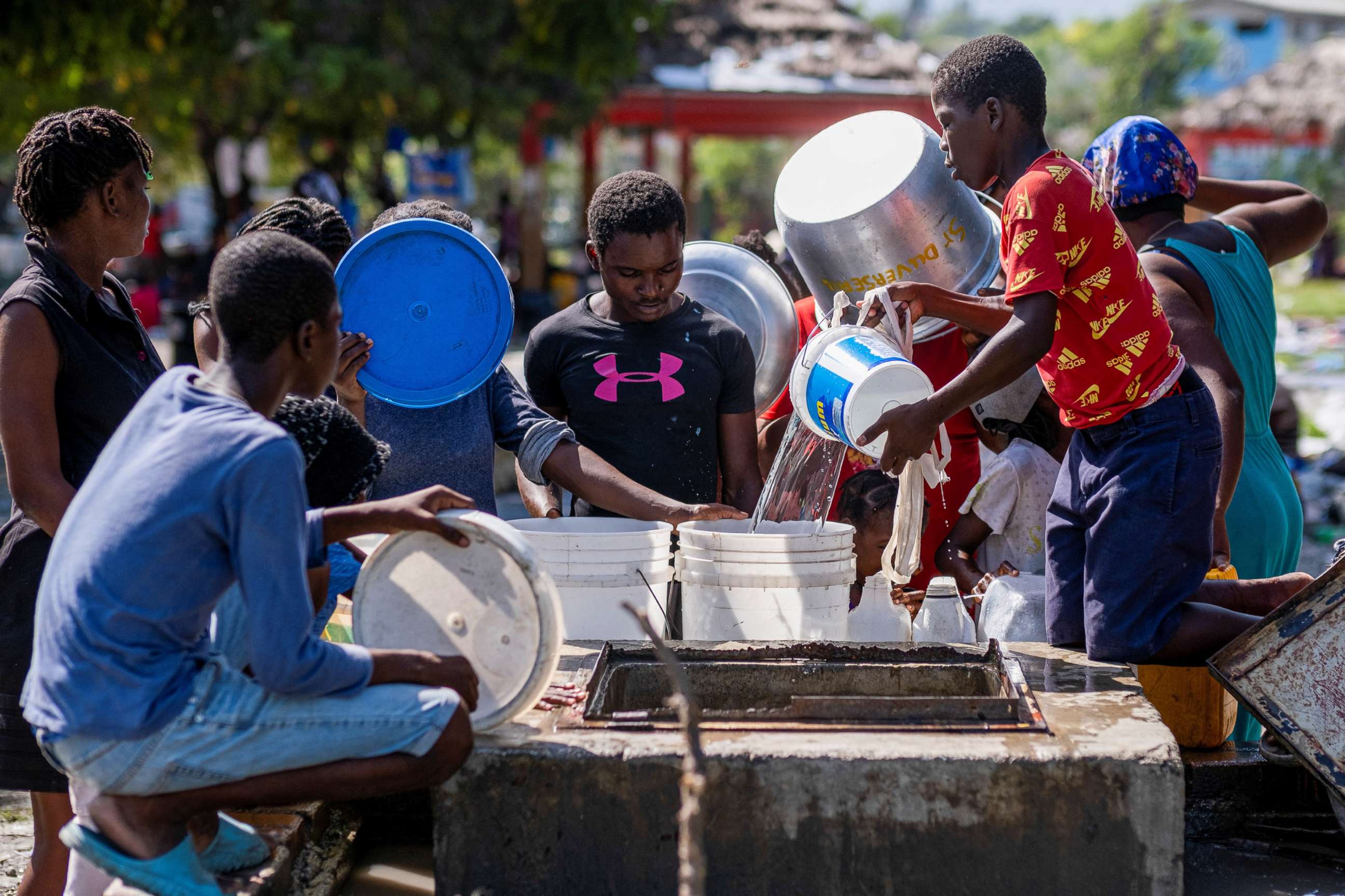 PHOTO: People displaced by gang war violence in Cite Soleil collect water from a well at the Hugo Chavez Square transformed into shelter living in inhumane conditions in Port-au-Prince, Haiti, Oct. 16, 2022. 