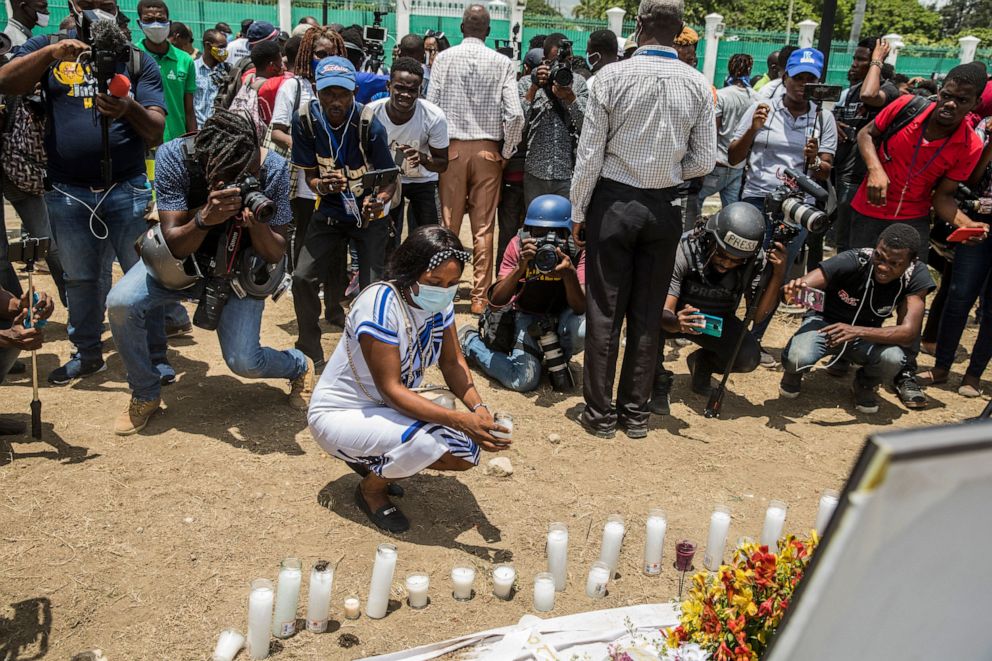 PHOTO: A person places a candle at a makeshift memorial outside of the Presidential Palace in Port-au-Prince on July 14, 2021, in the wake of Haitian President Jovenel Moise's assassination on July 7.
