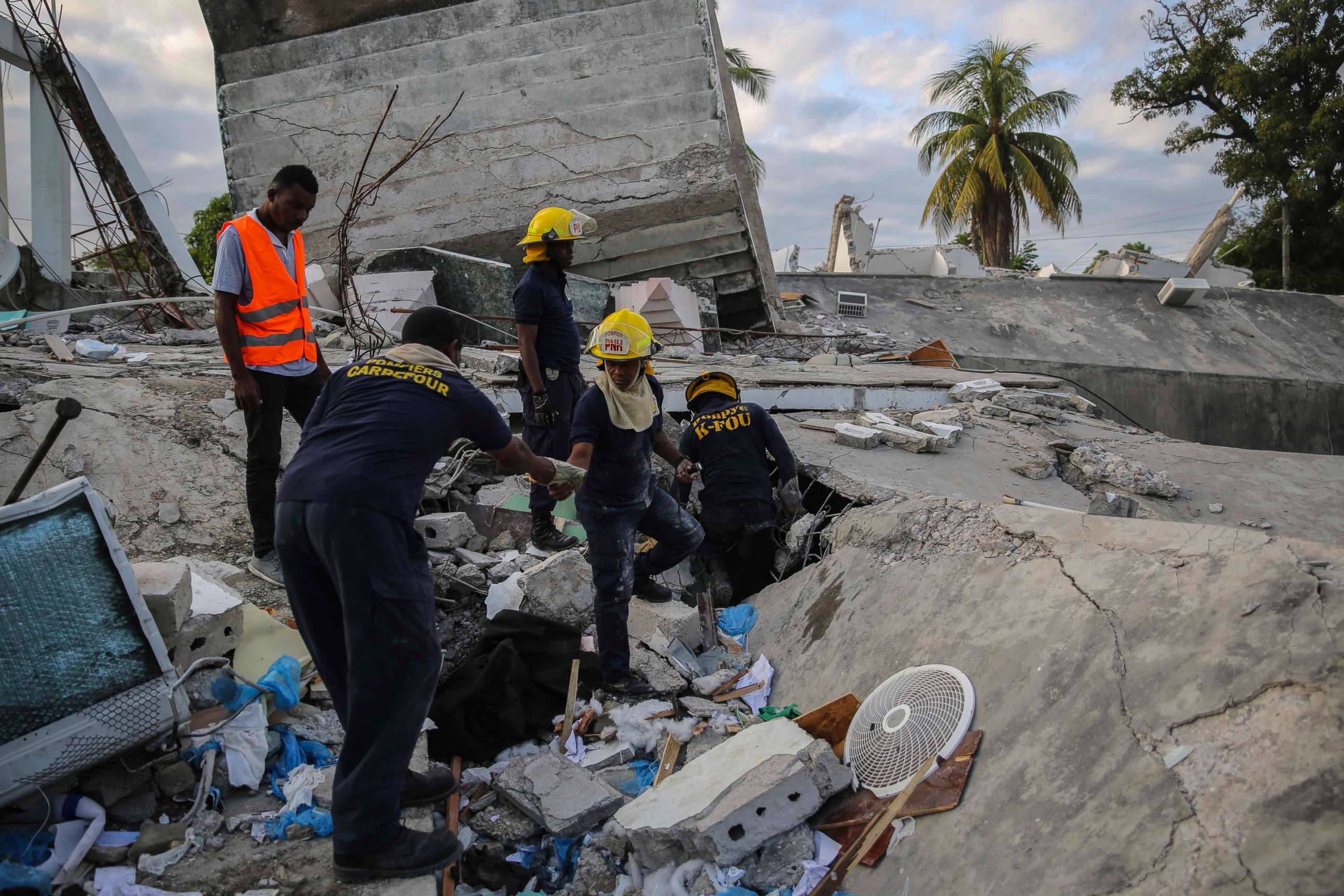 PHOTO: Firefighters search for survivors inside a collapsed building after a 7.2 magnitude earthquake in Les Cayes, Haiti, Aug. 15, 2021.