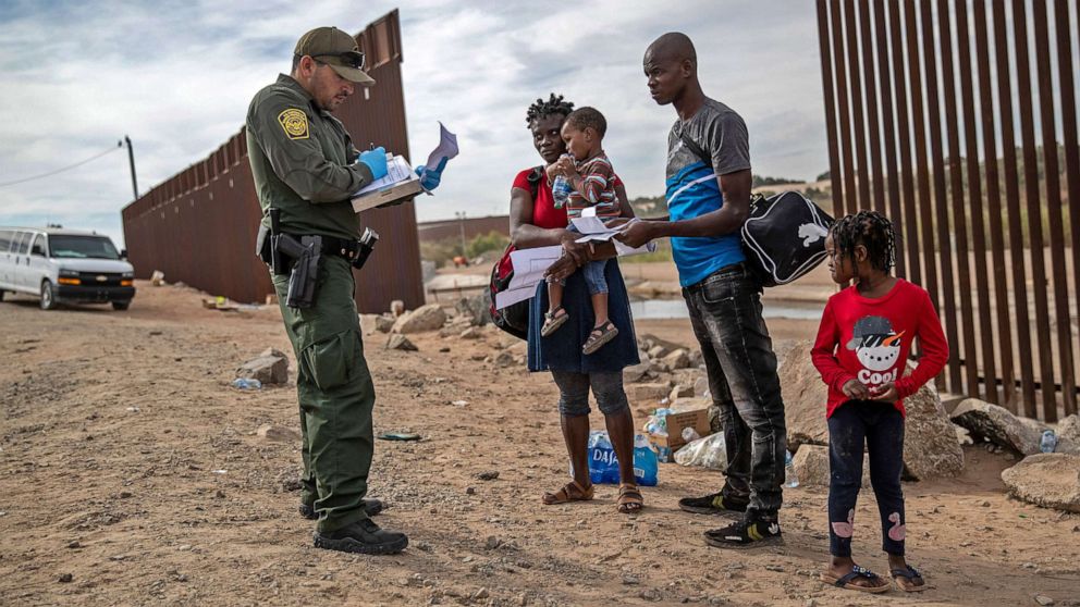 PHOTO: An immigrant family from Haiti is taken into custody by a U.S. Border Patrol agent at the U.S.-Mexico border on Dec. 7, 2021 in Yuma, Ariz. Many families apply for asylum upon arrival to the U.S.
