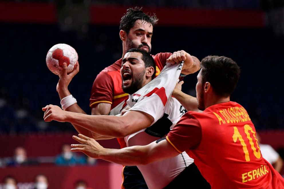 PHOTO: Egypt's left back Ahmed Mohamed is challenged by Spain's centre back Raul Entrerrios during the men's bronze medal handball match on Aug. 7, 2021.