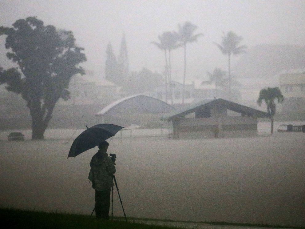 PHOTO: A man takes photos of floodwaters from Hurricane Lane rainfall on the Big Island, Aug. 23, 2018, in Hilo, Hawaii. Hurricane Lane has brought more than a foot of rain to some parts of the Big Island which is under a flash flood warning.