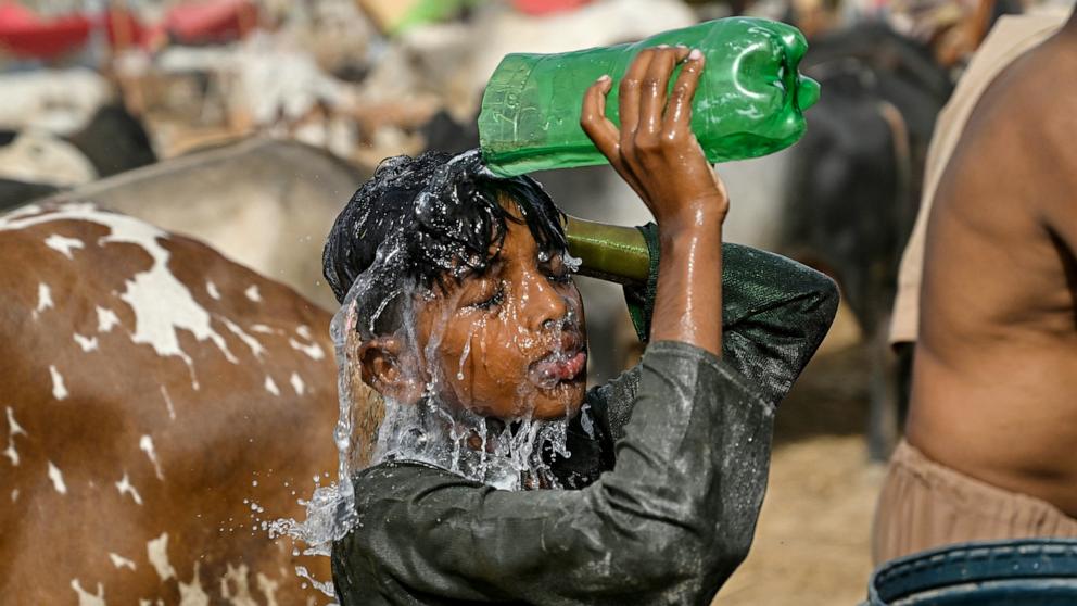 PHOTO: A child pours water to cool off on a hot summer day, at a cattle market in Karachi, Pakistan, May 31, 2025. 